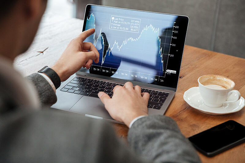 cortada imagem empresario sentado junto a mesa no cafe e analisando indicadores no computador portatil