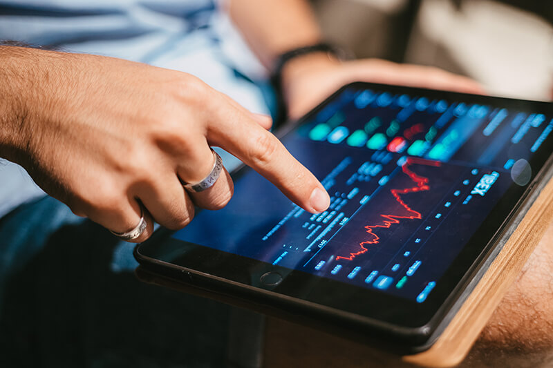 homem verificando dados mercado de acoes no tablet